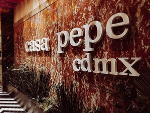 The sign for casa pepe cdmx all in lowercase letters on an orange marble