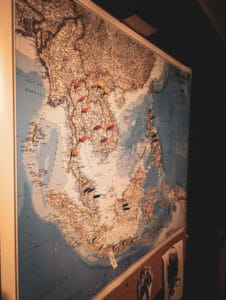 Map of southeast asia with a variety of colours of flag pins spread around it, all posted on a corkboard